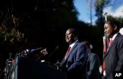 Kenya's opposition leader Raila Odinga, center, accompanied by party official Kalonzo Musyoka, right, announces they will challenge the results of the August 8 presidential election in the Supreme Court.