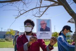 An African-American holding a portrait picture of Vicha Ratanapakdee during the Asian American event to raise awareness about the increase in hate crimes against Asians in the US near Chinatown Los Angeles, CA.