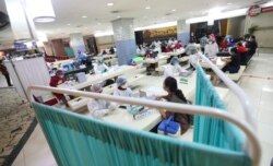 Para pedagang di Pasar Tanah Abang menerima suntikan vaksin COVID-19 dalam kegiatan vaksinasi massal, Jakarta, 18 Februari 2021. (Foto: Achmad Ibrahim/AP)