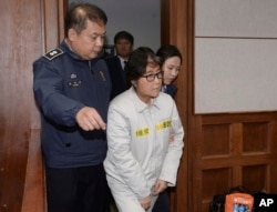 Choi Soon-sil, center, the jailed confidante of disgraced South Korean President Park Geun-hye, appears for the first day of her trial at the Seoul Central District Court in Seoul, South Korea, Dec. 19, 2016.