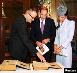 FILE - Britain's Prince William (C) and his wife Catherine, Duchess of Cambridge, (R) prepare to sign the First Fleet Bible and Prayer Book following Easter Sunday Service at St Andrews Cathedral in Sydney, April 20, 2014.