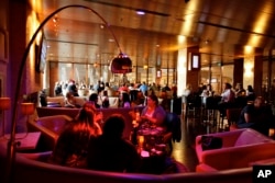 FILE - Movie-goers enjoy drinks at The Landmark Movie Theatre's bar lounge, before the start of their film in Los Angeles, Aug. 14, 2009.
