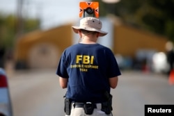 FILE - An FBI agent investigates the site of the shooting at the First Baptist Church of Sutherland Springs, Texas, Nov. 7, 2017.