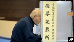 A voter selects candidates before casting a ballot in Japan's upper house parliamentary elections at a polling station in Tokyo, Sunday, July 10, 2016.