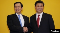 FILE - Chinese President Xi Jinping shakes hands with Taiwan's President Ma Ying-jeou during a summit in Singapore, Nov. 7, 2015.