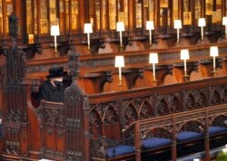 FILE - Britain's Queen Elizabeth II sits alone in St. George's Chapel during the funeral of Prince Philip, her husband of 73 years, at Windsor Castle, Windsor, England, April 17, 2021.