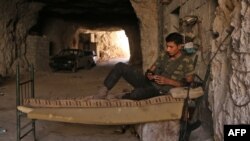 Seorang pemberontak Suriah beristirahat di lokasi yang tidak disebutkan di provinsi Idlib, Rabu (5/9).