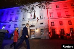 U.S. Secretary of State John Kerry (C), next to U.S. ambassador to France Jane D. Hartley, leaves after delivering a speech at the U.S. embassy in Paris illuminated with the colors of the French national flag, Nov. 16, 2015.