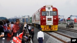 FILE - Kenyan President Uhuru Kenyatta, third from left, watches the opening of the SGR cargo train as it leaves the port containers depot in Mombasa to Nairobi, May 30, 2017. The project, a $3.3 billion investment backed by China, is the country's largest infrastructure project.