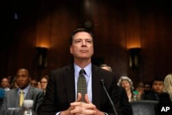 FILE - Then-FBI Director James Comey prepares to testify on Capitol Hill in Washington, May 3, 2017, before the Senate Judiciary Committee hearing: "Oversight of the Federal Bureau of Investigation."