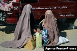 Žene nose hranu koju dijeli Crveni krst u Kandaharu, Afganistan, 15. decembra 2021.