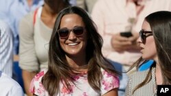 FILE - Pippa Middleton, left, the sister of Kate, the Duchess of Cambridge, watches the quarterfinal tennis match between Canada's Milos Raonic and France's Gilles Simon on the fifth day of the Queen's Championships in London.