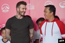 Menteri Pemuda dan Olahraga Imam Nahrawi bersama mantan pemain sepak bola profesional David Beckham dalam acara amal di Jakarta, 25 Maret 2018. (Foto: Adek Berry/AFP)