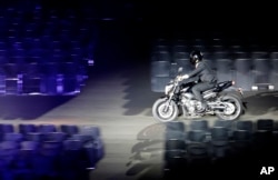 Presiden Indonesia Joko Widodo mengendarai sepeda motor, menghadiri upacara pembukaan Asian Games ke-18 di Stadion Gelora Bung Karno, Jakarta, Indonesia, Sabtu, 18 Agustus 2018. (AP Photo / Lee Jin-man)