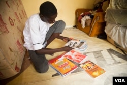 Abdulkadir Abdullahi, 17, looks through his brand-new textbooks in Maiduguri, Nigeria, October 2016. (C. Oduah/VOA)