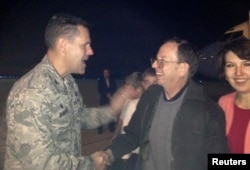 Jeffrey Fowle and his wife, Tatyana, are greeted by U.S. Air Force Col. John Devillier upon arrival at Wright-Patterson Air Force Base in Ohio after his release in North Korea, Oct. 22, 2014.