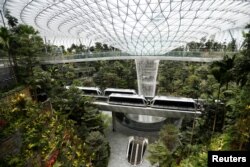 Sebuah kalayang yang menghubungkan berbagai terminal di Bandara Changi tampak melintas di Jewel Complex, Singapura, 11 April 2019. (Foto: Reuters/Feline Lim)