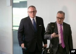 FILE - Former Donald Trump campaign official Michael Caputo, left, joined by his attorney Dennis C. Vacco, leaves after being interviewed by Senate Intelligence Committee staff investigating Russian meddling in the 2016 presidential election, on Capitol Hill in Washington, May 1, 2018.