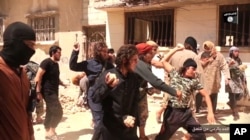 FILE - In this picture posted on a social media account affiliated with the Islamic State group, June 14, 2015, IS militants stone a man accused of violating the extremists' ban on homosexuality after they threw him from a roof in the city of Homs, Syria.