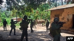 Des soldats de l'armée congolaise (FARDC) entourent une maison soupçonnée d'abriter un groupe de rebelles Mai Mai à Mboko, au Sud-Kivu, 10 novembre 2009.