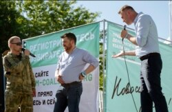FILE - Russian opposition activist Alexei Navalny, right, argues with a man in a military uniform, left, as opposition activist Leonid Volkov, center, listens during a rally in Novosibirsk, Siberia's biggest city, Russia, June 7, 2015.