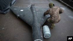 ທະຫານນາຍຮ້ອຍຂອງຢູເຄຣນ ກຳລັງກວດເບິ່ງ ໂດຣນ ຊາເຫດ ລຳນຶ່ງ ທີ່ໄດ້ຖືກຍິງຕົກ ທີ່ຕິດອາວຸດດ້ວຍລະເບີດຄວາມຮ້ອນສູງ ສົ່ງມາໂດຍຣັດເຊຍ, ຢູ່ໃນຫ້ອງວິໄຈ ແຫ່ງນຶ່ງທີ່ບໍ່ເປີດເຜີຍສະຖານທີ່ໃນຢູເຄຣນ, ວັນທີ 14 ພະຈິກ 2024. (AP Photo/Efrem Lukatsky)