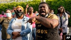 People gather outside the municipal building after at least one Pasquotank County Sheriff's deputy shot and killed a Black man while executing a search warrant, the sheriff's office said, April 21, 2021, in Elizabeth City, NC.