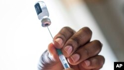 A nurse fills a syringe with COVID-19 vaccine at Soweto's Baragwanath hospital, South Africa, Dec. 13, 2021.