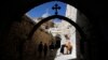 A priest kisses a cross near the Church of the Holy Sepulchre on Good Friday during Holy Week in Jerusalem's Old City, Mar. 29, 2013. 
