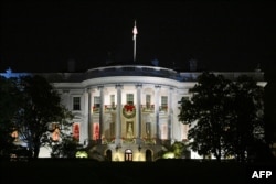 The White House is seen decorated with Christmas decorations during the unveiling of the holiday ice skating rink, on the South Lawn of the White House in Washington, DC, on November 29, 2023. (Photo by Mandel NGAN / AFP)