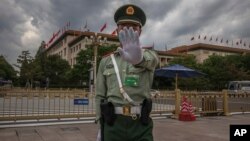 រូប​ឯកសារ៖ ទាហាន​ម្នាក់​នៃ​កង​ទ័ព​រំដោះ​ប្រជាជន​ចិន ​លើក​ដៃ​ឱ្យ​ឈប់​ថត​រូប​នៅ​​មុខ​​អគារ​មហាសាល​ប្រជាជន​ចិន​ក្នុង​ទី​ក្រុង​ប៉េកាំង​កាល​ពី​ថ្ងៃ​ទី​​២៥ ខែ​ឧសភា ឆ្នាំ​២០២០។