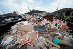 Debris piles up at curbside as residents gut their flooded homes in the aftermath of Hurricane Ida in LaPlace, La., Sept. 7, 2021.