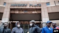 Para pekerja Informal di depan gedung balai kota di Braamfontein, Afrika Selatan, untuk mengajukan permohonan izin kerja di tengah pemberlakukan karantina wilayah, 8 April 2020.