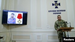 A photo of the director of the Kyiv office of Russian state news agency RIA Novosti Kirill Vyshinsky is seen on a monitor during a news briefing at the headquarters of the Ukraine's state security service (SBU) in Kyiv, Ukraine, May 15, 2018. 