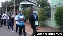 Les membres de la Lucha lors d'une marche pacifique, mains liées et bouche bandée en signe de solidarité avec leur camarades arretés à Kinshasa et à Goma, sur une route en plein centre ville de Goma, le 15 mars 2016.