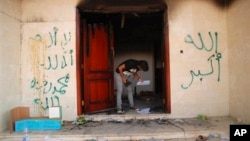 រូបឯកសារ៖ បុរស​ម្នាក់​កំពុង​មើល​​ឯកសារ​នៅ​អគ្គ​កុងស៊ុល​អាមេរិក​ក្នុង​ទីក្រុង​ Benghazi ប្រទេស​លីប៊ី ដែល​ត្រូវ​បាន​វាយ​ប្រហារ​ ហើយ​ជន​ជាតិ​អាមេរិកាំង​៤​នាក់​ត្រូវ​បាន​​សម្លាប់​ កាល​ពី​ឆ្នាំ​២០១២។