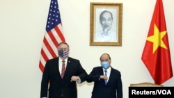 Menlu AS MIke Pompeo bersama PM Vietnam Nguyen Xuan Phuc, memberikan salam dengan siku tangannya, menjelang pertemuan di Hanoi, Vietnam, 30 Oktober 2020. (Thong Nhat/Vietnam News Agency via REUTERS).