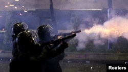 FILE - Law enforcement officers fire tear gas canisters as fireworks explode during a protest against the new government's decision to suspend the European Union accession talks and refuse budgetary grants until 2028, in Tbilisi, Dec. 2, 2024.