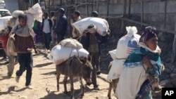 FILE - Families begin their journey home from the Estayesh Food Distribution Site in Ethiopia, Dec. 14, 2015.