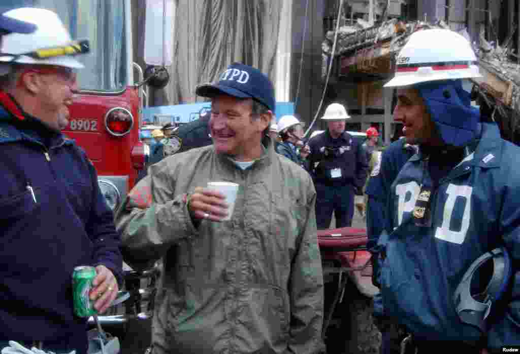 Aktor dan komedian Robin Williams (tengah) tertawa bersama tim SAR dekat lokasi runtuhnya World Trade Center di lower Manhattan, 17 Oktober 2001. Williams menghabiskan waktu dengan tim SAR dan memberikan kejutan pada para istri mereka melalui telepon.