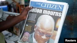 A man holds a newspapers following the death of Tanzania's President John Magufuli in Dar es Salaam, Tanzania, March 18, 2021.