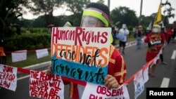 A protestor, maintaining social distancing from others to prevent the spread of coronavirus disease (COVID-19), holds a placard that reads "Human Rights Defenders are not terrorists" during a rally against the anti-terror bill in Manila.