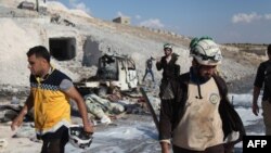 សមាជិក​ការពារ​ជន​ស៊ីវិល​ស៊ីរីពិនិត្យ​មើល​ឡាន​​និង​សម្ភារៈ​ដែល​បាន​ឆេះ​នៅ​ក្រុង Hass​ ក្រោយ​ពេល​មាន​ការ​វាយ​ប្រហារ​តាម​អាកាស​នៅ​ផ្នែក​ខាង​ត្បូង​នៃ​ខេត្ត Idlib កាល​​ពី​ថ្ងៃ​ទី​៨ កញ្ញា ២០១៨។