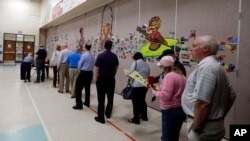 FILE - People line up to vote inside a precinct in Matthews, N.C., March 15, 2016. 