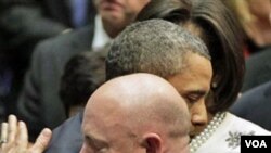 Presiden Barack Obama memeluk Mark Kelly, suami anggota DPR Gabrielle Gifford pada akhir upacara menghormati para korban penembakan di Tucson, Arizona, Kamis.
