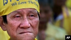 FILE - An elderly man listens to King Bhumibol Adulyadej make a speech on a giant screen, on the king's 86th birthday at the Democracy Monument in Bangkok, Dec. 5, 2013.