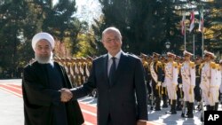 Iraqi President Barham Salih, right, and his Iranian counterpart Hassan Rouhani shake hands during an official welcome ceremony for Salih at the Saadabad Palace in Tehran, Iran, Saturday, Nov. 17, 2018.