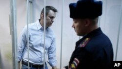 Aktivis anti-Kremlin Rusia, Alexei Navalny, di balik jeruji pengadilan di Moskow. (Foto: Dok)