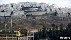Un site de construction dans une colonie israelienne de Ramot site in the Israeli settlement of Ramot, as the Israeli settlement of Ramat Shlomo is seen in the background, in an area of the occupied West Bank that Israel annexed to Jerusalem, Jan. 22, 2017.
