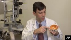 Dr. Jason Comander, inherited retinal disorder specialist at Massachusetts Eye and Ear Infirmary in Boston points to a model of an eye during an interview on Jan. 8, 2020. Comander's hospital plans to enroll patients in a gene editing treatment for blindn